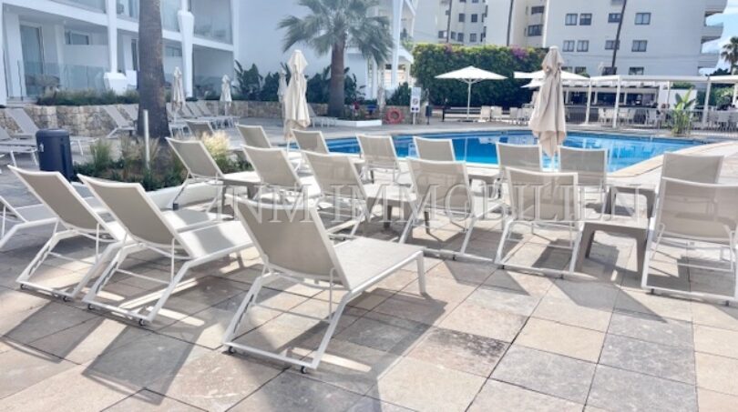 Poolbereich mit weißen Liegestühlen und Sonnenschirmen im Apartment-Komplex Palmanova, Palma Nova