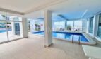 Überdachter Innenpool mit Glasfronten und Blick auf Außenpool im Apartment-Komplex in Palmanova