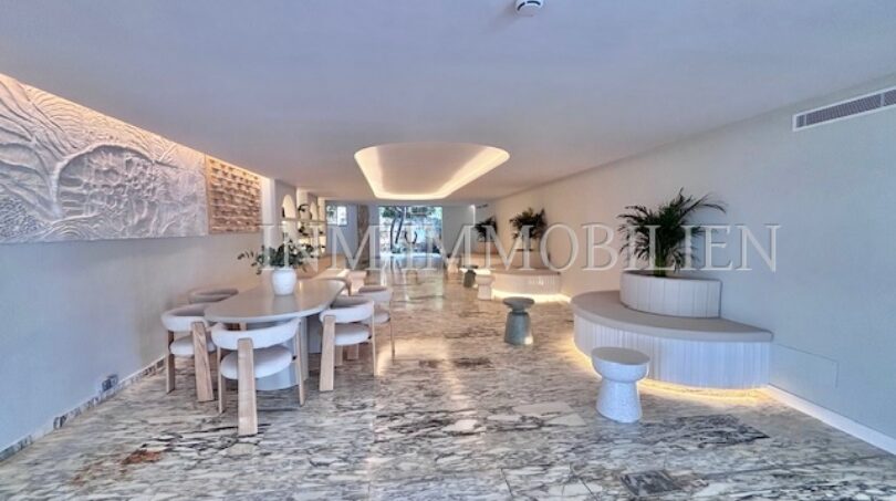Eleganter Wohn-Essbereich mit Marmorboden, Designermöbeln und indirekter Beleuchtung in Palmanova-Apartment