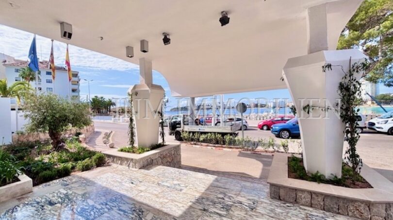 Überdachter Eingangsbereich mit Marmorboden und weißen Säulen, Blick auf Parkplatz und Meer in Palmanova