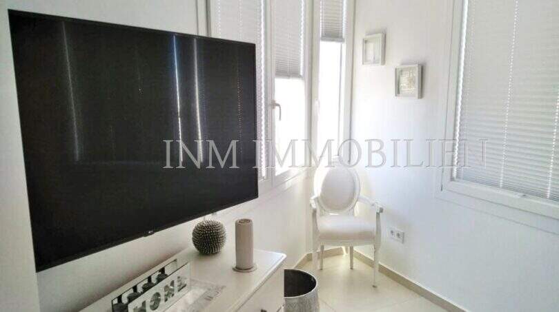 Helles Schlafzimmer im Penthouse mit TV, weißem Stuhl und Balkonzugang, Playa de Palma