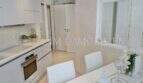 Moderne weiße Einbauküche mit Esstisch im Luxus-Penthouse an der Playa de Palma, Mallorca