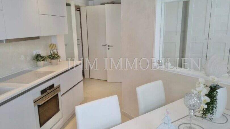 Moderne weiße Einbauküche mit Esstisch im Luxus-Penthouse an der Playa de Palma, Mallorca