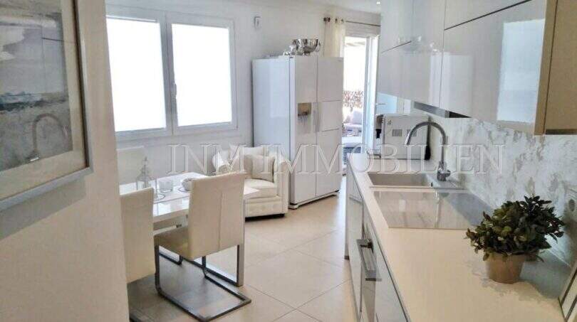 Moderne, weiße Küche mit Marmoroptik-Rückwand und offener Wohnbereich im Luxus-Penthouse Playa de Palma