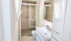 Modernes Badezimmer im Penthouse Playa de Palma mit Glasdusche, weißem Waschtisch und Spiegelschrank.