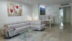 Helles Wohnzimmer mit grauem Ecksofa, Marmorboden und Esstisch in moderner Luxuswohnung in Bendinat.
