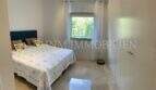 Helles Schlafzimmer der Luxuswohnung in Bendinat mit Doppelbett, Einbauschrank und Marmorböden.
