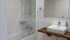 Modernes Badezimmer mit Badewanne, Dusche, Waschtisch auf Holzablage und Spiegel in Luxuswohnung Bendinat