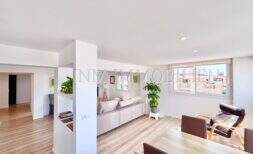 Helles Wohnzimmer mit Laminatboden, rosa Sofa, Ledersessel und großem Fenster in möblierter Wohnung Can Pastilla