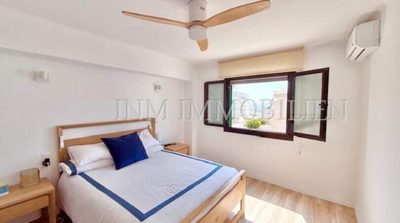 Helles Schlafzimmer mit Doppelbett, Holzmöbeln, Deckenventilator und Klimaanlage in Can Pastilla, Palma