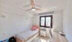 Helles Kinderzimmer mit Einzelbett, Schreibtisch, Deckenventilator und Fenster in Mietwohnung Can Pastilla, Palma