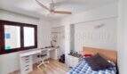 Helles Schlafzimmer mit Einzelbett, Schreibtisch, Deckenventilator und Parkettboden in Can Pastilla