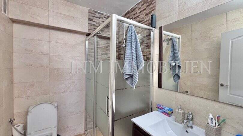 Modernes Badezimmer mit Glasdusche, WC und Waschtisch in möblierter Mietwohnung in Can Pastilla, Mallorca.