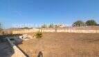 Weitläufiges Grundstück eines Landhauses in Portocristo mit trockenem Garten, Steinmauern und Bergblick.
