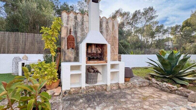 Outdoor-Grillkamin mit Steinpflaster, Agave und Palmen in exklusiver Ferienvilla nahe Strand Cala Murada