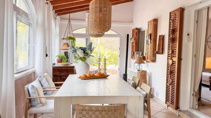 Heller Essbereich mit Holzbalkendecke, Rattanlampe, weißem Tisch und Orangendeko in Strandvilla Cala Murada