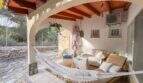 Überdachte Terrasse mit Hängematte, Korbmöbeln und Holzbalkendecke in mediterraner Finca nahe Cala Murada