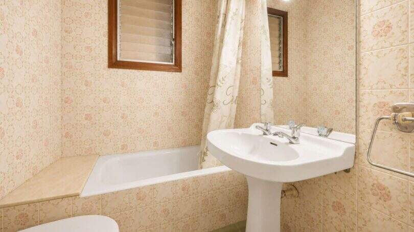 Badezimmer mit Badewanne, Standwaschbecken und floralen Fliesen in Wohnhaus, Felanitx