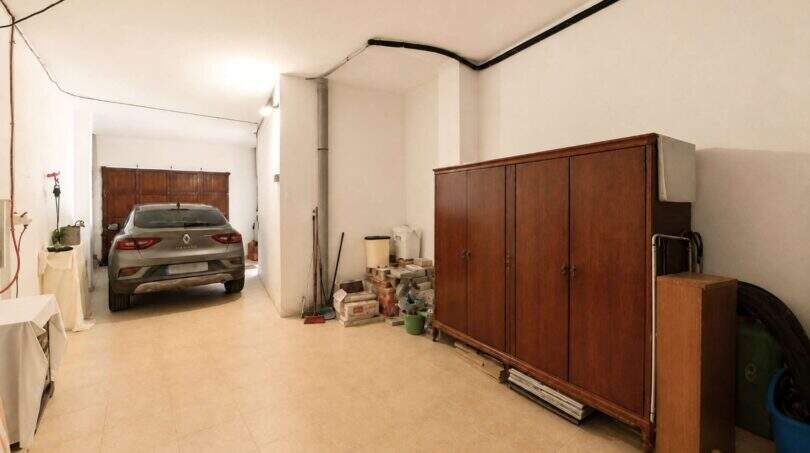 Geräumige Garage in Felanitx mit Renault, Holzschrank und Stauraum, heller Fliesenboden.