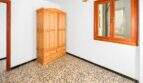 Leeres Schlafzimmer mit Holzschrank, Terrazzoböden und Holzfenster in Investitionsobjekt Felanitx