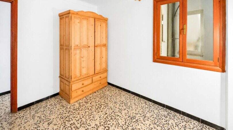 Leeres Schlafzimmer mit Holzschrank, Terrazzoböden und Holzfenster in Investitionsobjekt Felanitx