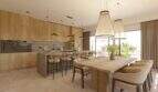 Offene Küche mit Holzfront, Kochinsel und Essbereich mit großem Holztisch in Designvilla Cala Murada