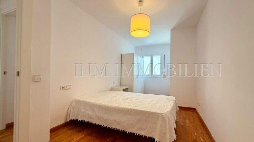 Helles Schlafzimmer mit Doppelbett, Holzboden und Fenster in Dachgeschosswohnung Palma Blanquerna