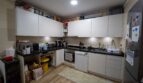 Cocina empotrada moderna con frentes blancos, encimera de granito, lavavajillas y estufa en unidad de vivienda alquilada, Felanitx