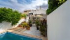 Patio interior con piscina, plantas de terraza e invernadero cubierto de una casa multifamiliar en Felanitx