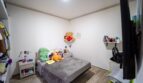 Habitación infantil con cama individual, ositos de peluche, estantería mural y armario empotrado en casa de múltiples familias Felanitx