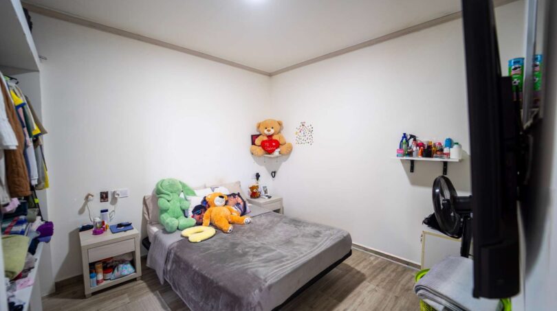 Habitación infantil con cama individual, ositos de peluche, estantería mural y armario empotrado en casa de múltiples familias Felanitx