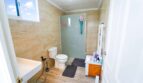 Baño con cabina de ducha, inodoro, bañera y suelo de madera en casa unifamiliar alquilada en Felanitx