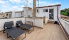 Terraza de azotea con baldosas de madera, dos tumbonas y pequeña construcción en Felanitx, Mallorca