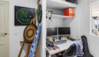Oficina en casa con configuración de doble monitor, estantería empotrada y arte de pared decorativo en casa multifamiliar Felanitx