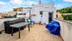 Terraza de azotea con tarimas de madera, muebles de jardín y vistas a los tejados de la ciudad de Felanitx