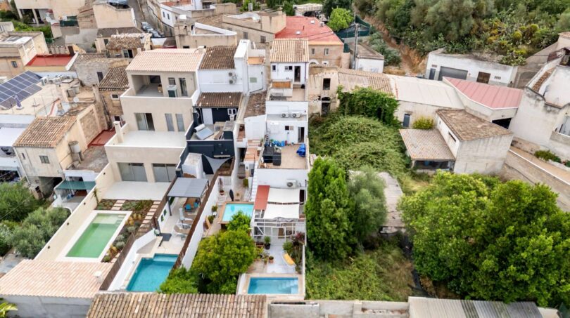 Fotografía aérea de una casa multifamiliar alquilada en Felanitx con piscinas, terrazas y arquitectura mediterránea.