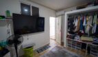 Dormitorio con TV montada en pared, armario abierto y aire acondicionado en casa de múltiples familias Felanitx