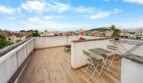 Terraza de azotea con baldosas de madera, juego de bistró y vista a la ciudad en casa de múltiples familias alquilada en Felanitx