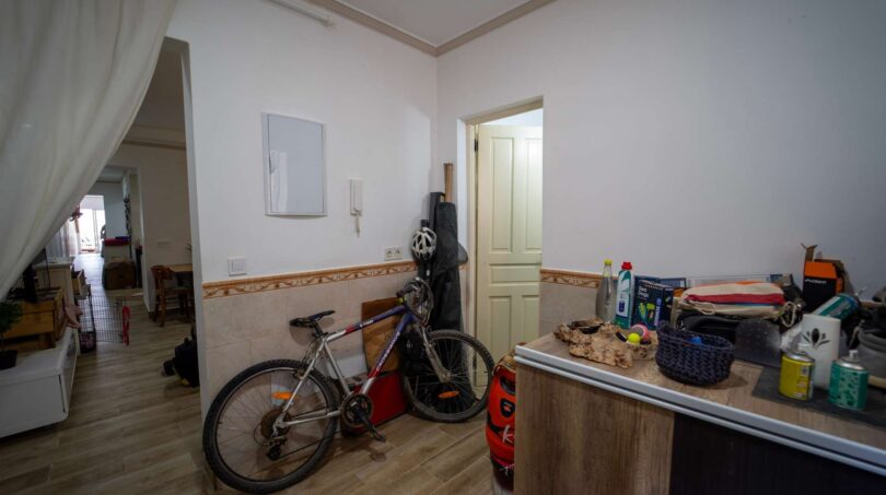 Entrada con zócalo de azulejos, bicicleta y paso al salón en la casa multifamiliar alquilada en Felanitx.