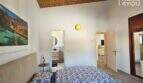 Schlafzimmer mit Doppelbett, En-Suite-Bad, Holzdecke und Meerblick-Kunstwerk im Bungalow Alcúdia