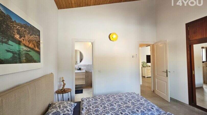 Schlafzimmer mit Doppelbett, En-Suite-Bad, Holzdecke und Meerblick-Kunstwerk im Bungalow Alcúdia