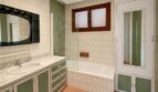 Retro bathroom with green cabinets, marble sink, bathtub and wall tiles in Villa Porto Cristo