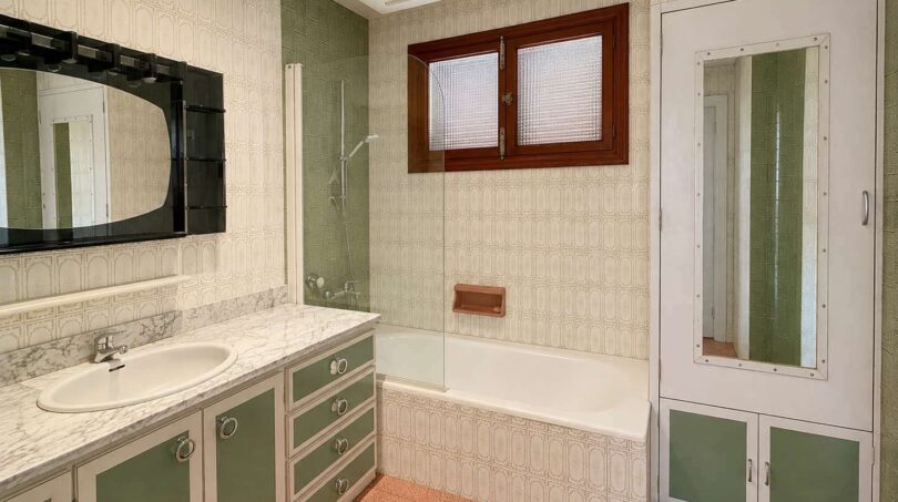 Retro bathroom with green cabinets, marble sink, bathtub and wall tiles in Villa Porto Cristo