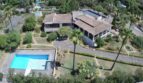 Aerial view of a Mediterranean villa in Porto Cristo with pool, palm garden and terracotta roof.