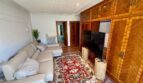 Living room of the retro villa in Porto Cristo with leather sofa, wooden cabinet and oriental rug
