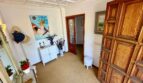 Elegant entrance area of the retro villa in Porto Cristo with coffered ceiling and rustic wooden door.