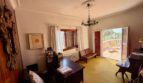 Office of the retro villa in Porto Cristo with wooden desk, chandelier and access to terrace with sea view.