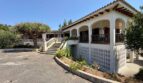 Outside view of the retro villa in Porto Cristo with white facade, arcades, balcony and large entrance area.
