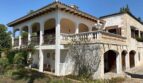 Outside view of the retro villa in Porto Cristo with arcades, balcony and Mediterranean architecture.