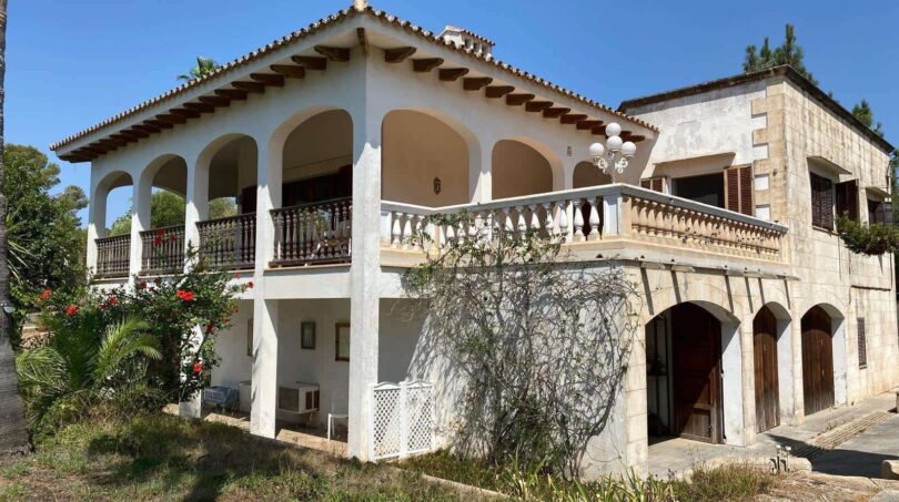 Outside view of the retro villa in Porto Cristo with arcades, balcony and Mediterranean architecture.